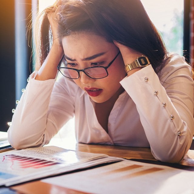 Worried businesswoman looking at charts on a desk