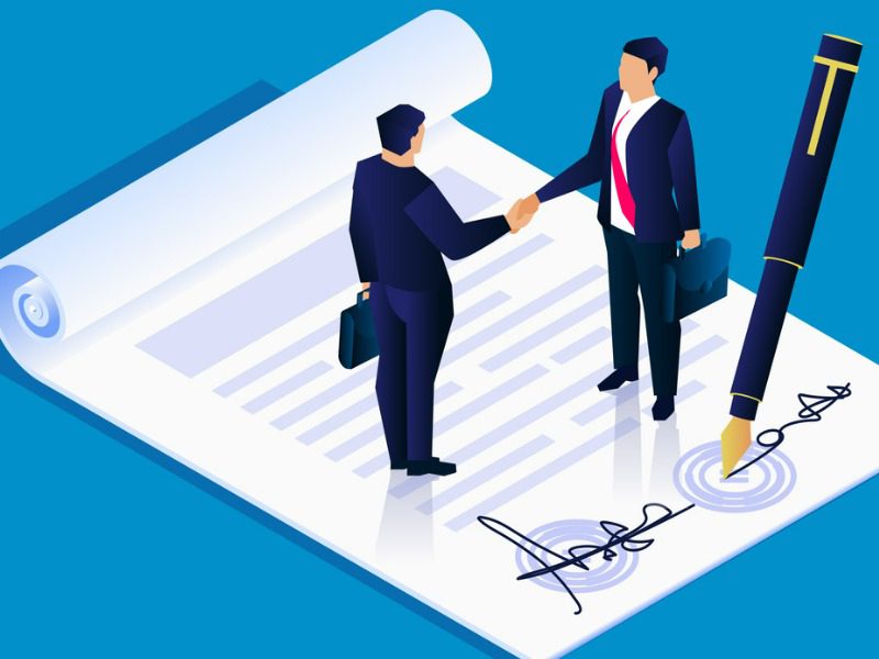 Businesspeople shaking hands over a signed contract