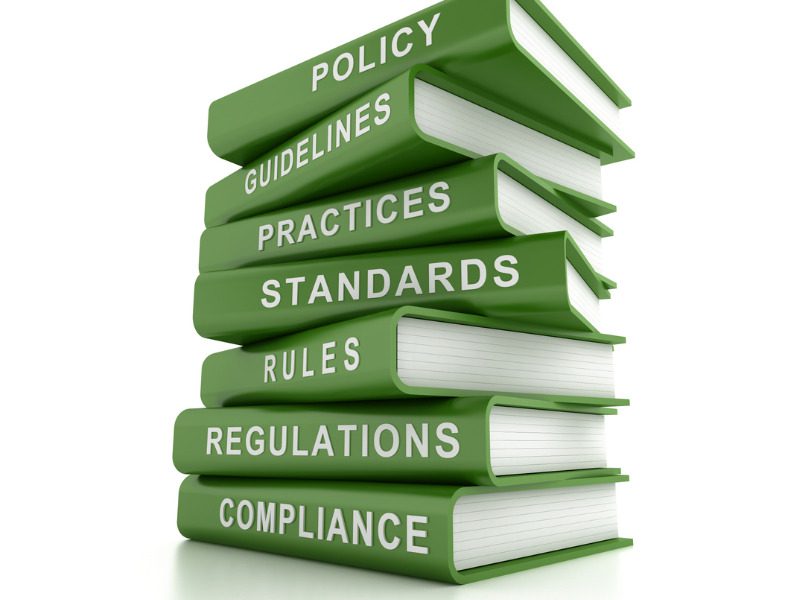 Stack of green compliance and rules books