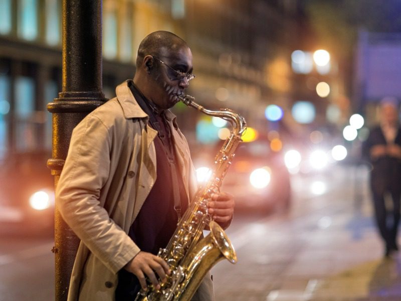 Busker playing a saxophone on a city street