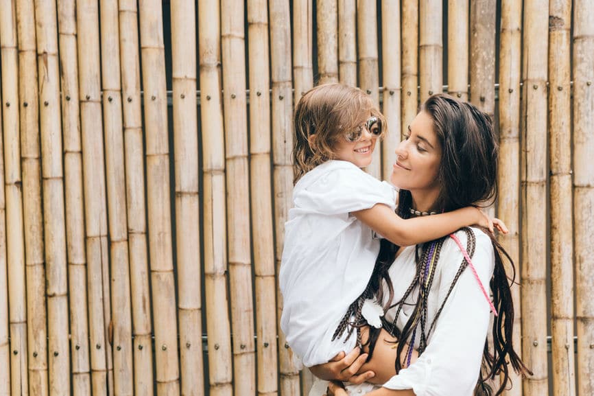 Mom holding toddler boy with a bamboo backdrop