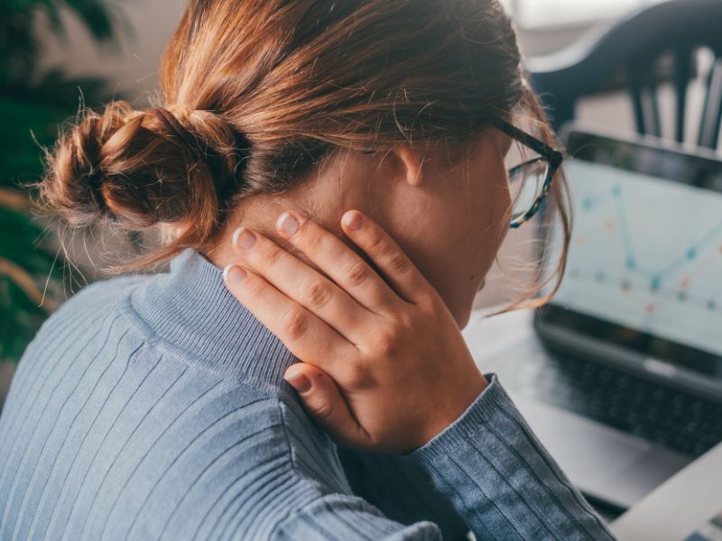 young woman holding her neck feeling pain