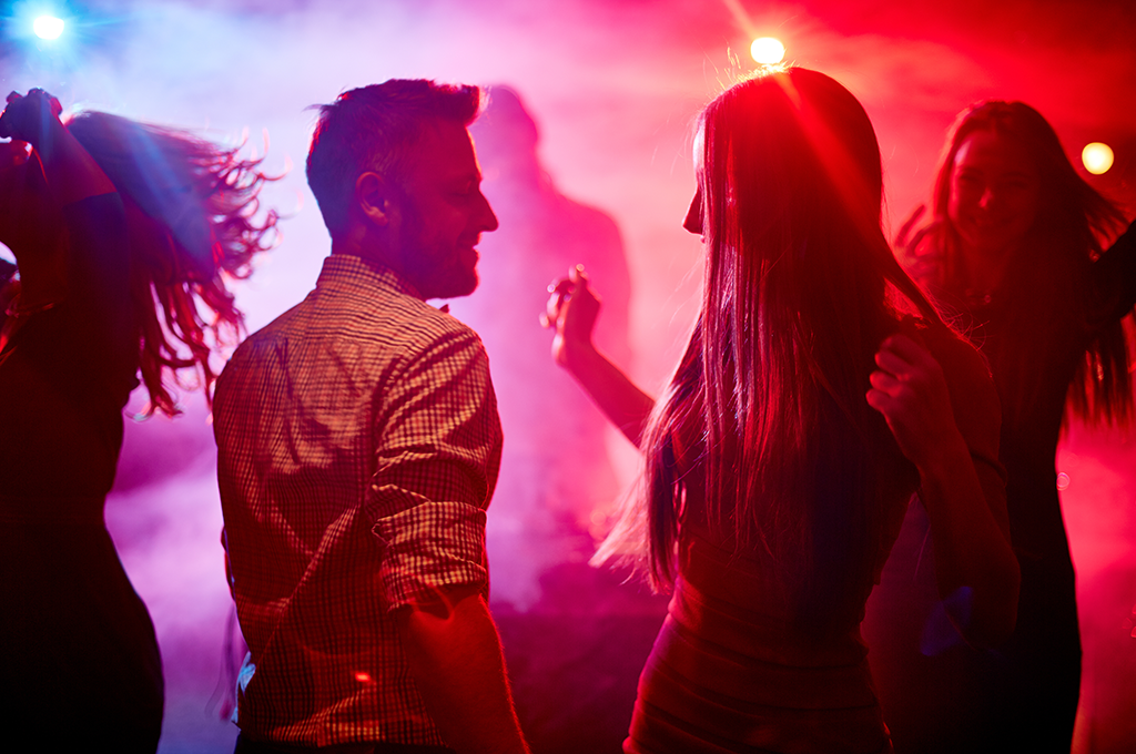 two people having fun dancing on a dancefloor in a club