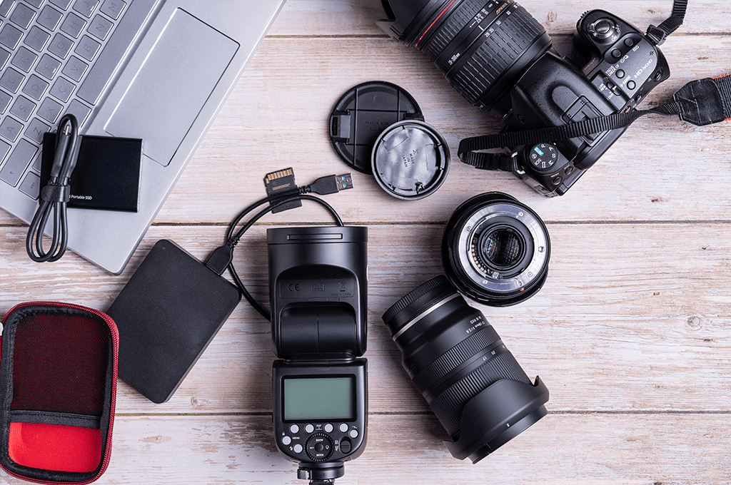 various items of camera equipment viewed from above on a wooden table top