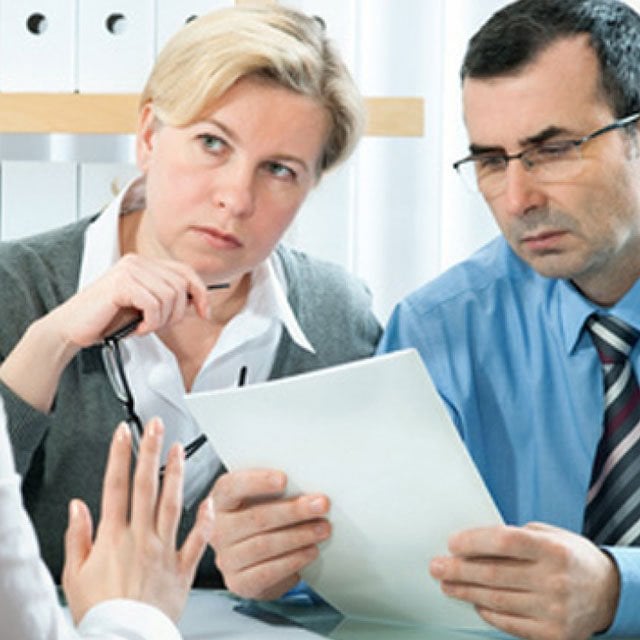 Couple looking at a business plan or report with skepticism