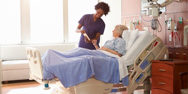 a nurse helps a woman in an upmarket singapore hospital ward bed