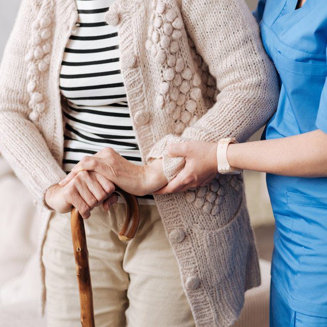 An aide helping an older woman