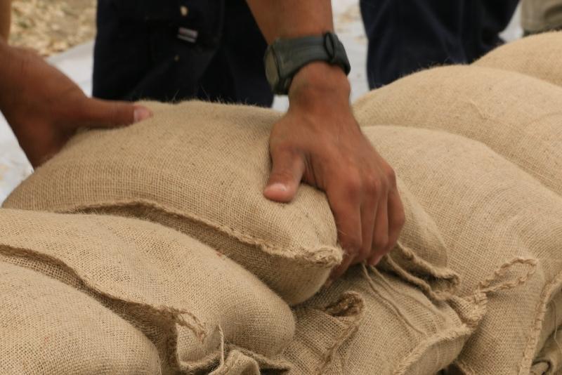 Man piling sandbags due to flooding - A-Plan Insurance