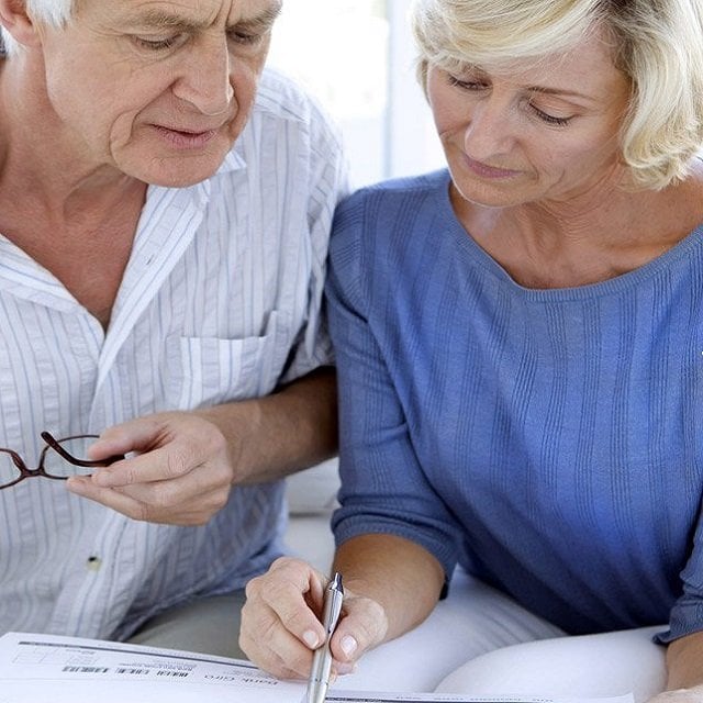 Senior couple signing papers