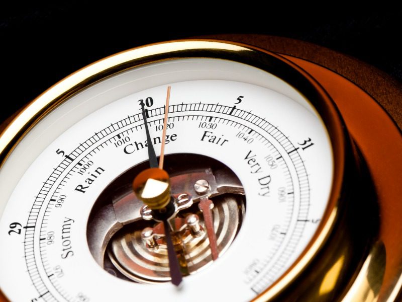 Close up shot of a barometer pressure gauge ranging from "stormy" to "very dry"