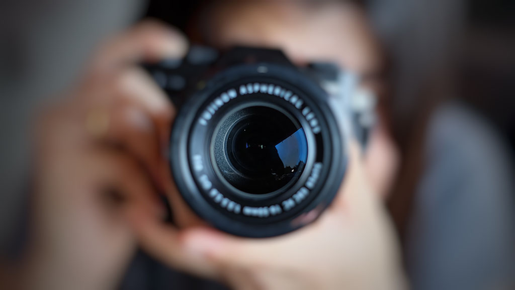 Soft focus of photographer holding a camera and taking a photo