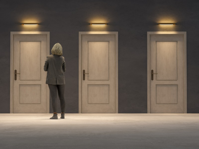 Broker standing in front of a series of doors, representing choices.