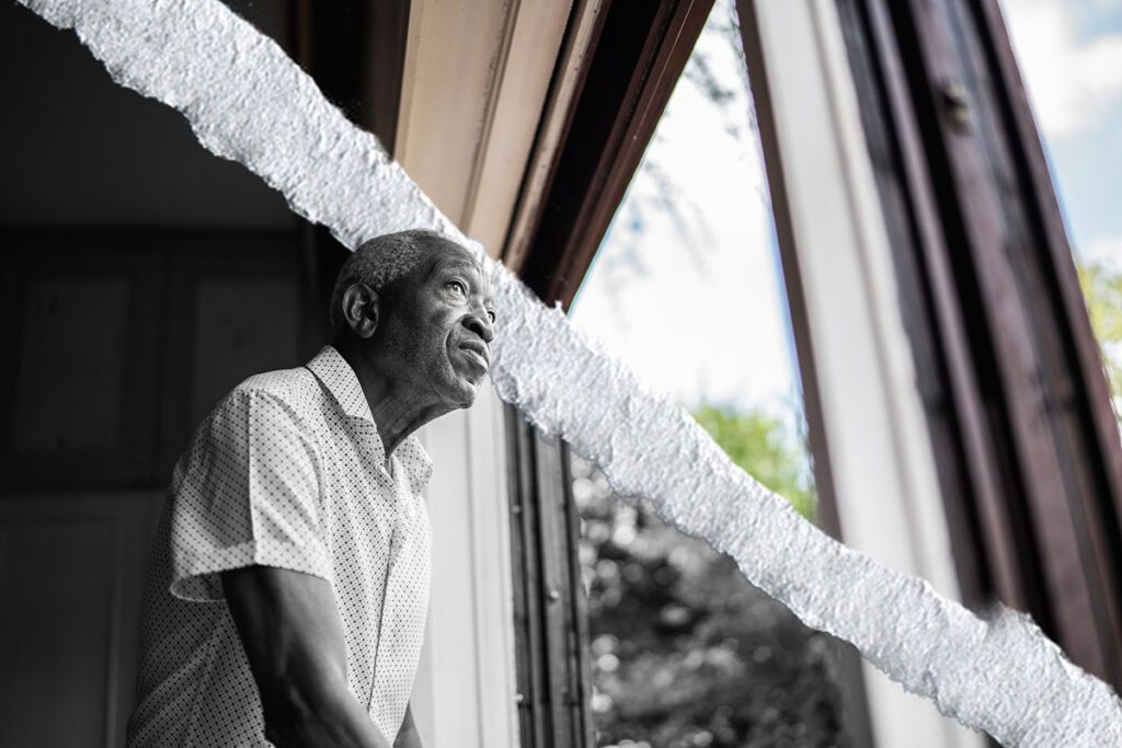 An older man looks out the window.