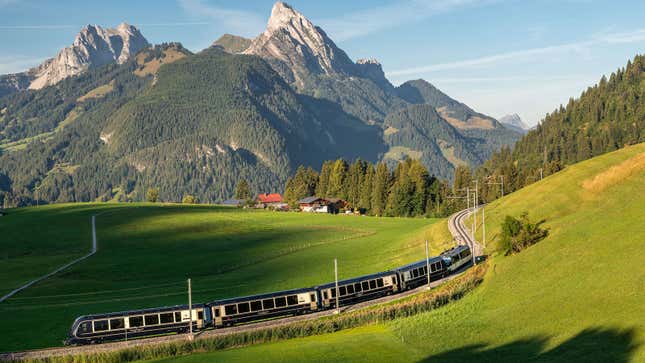 A photo of the Golden Pass train passing in front of a mountain. 