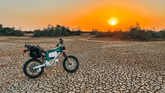 A photo of a Cake Kalk electric motorbike at sunset. 