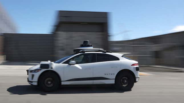 A photo of a white Waymo self-driving car. 