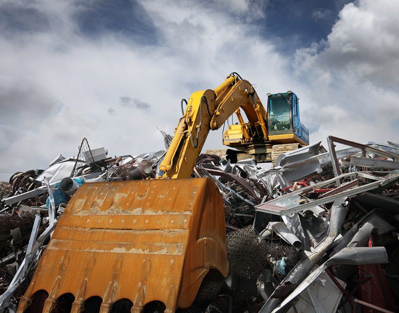 Excavator working at garbage dump.