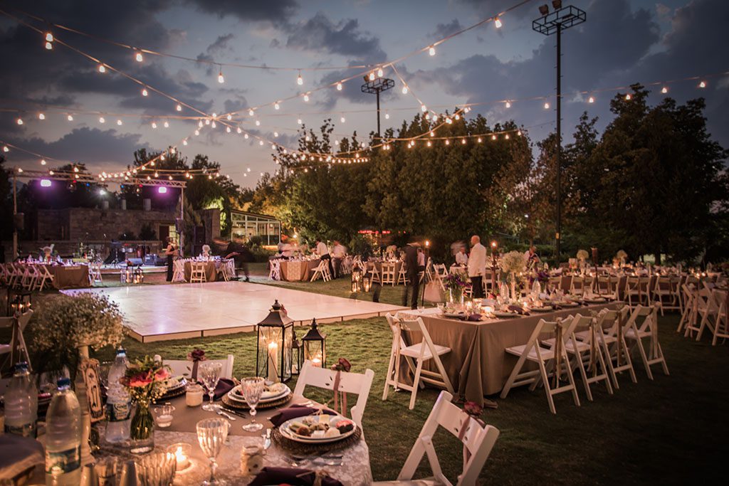 Wedding Ceremony with flowers outside in the garden with hanging lights