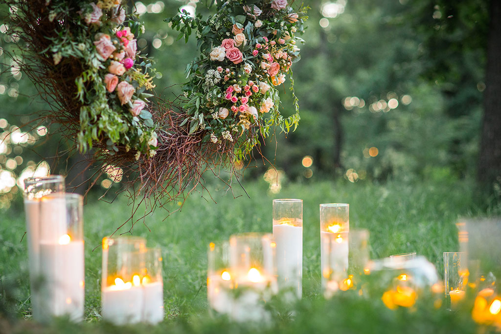 Wedding decor, candles in glass flasks in the forest.