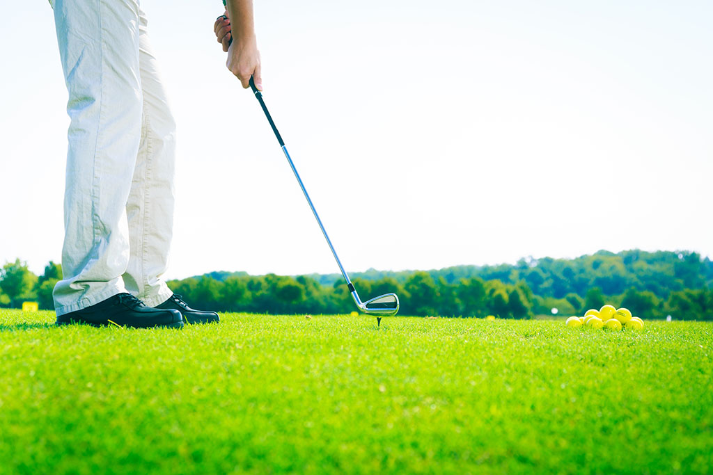 golf player practising their swing on a sunny day 