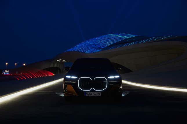 Front view at night of the headlights and illuminated grille of the 2024 BMW i7 M70 xDrive