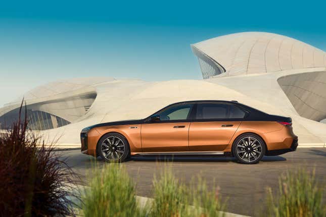 Side view of a 2024 BMW i7 M70 xDrive in front of a concrete structure