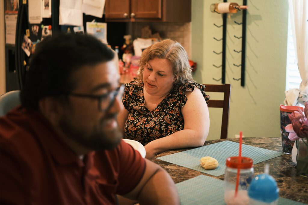 A photo of a woman and her husband sitting at home.