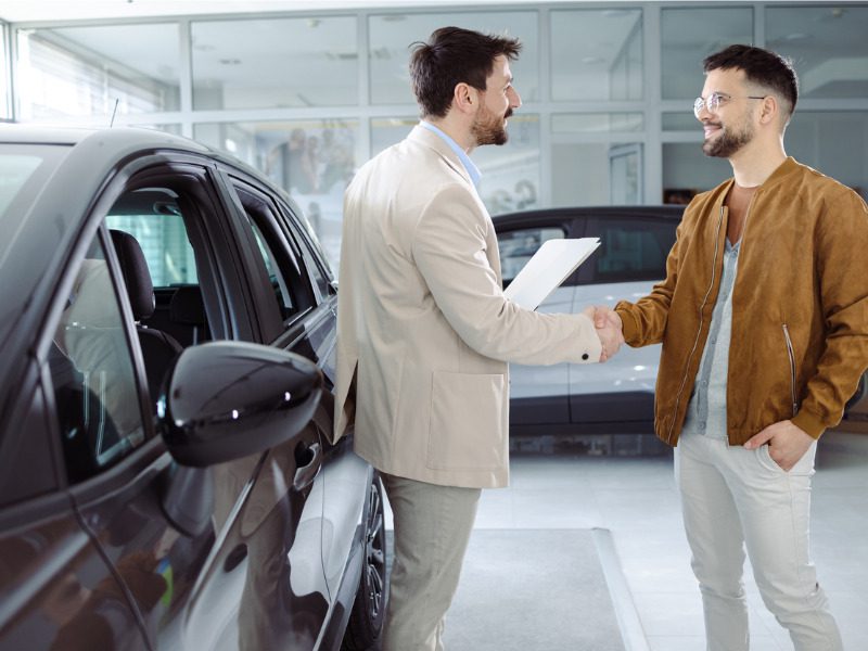 Salesman selling cars at a dealership