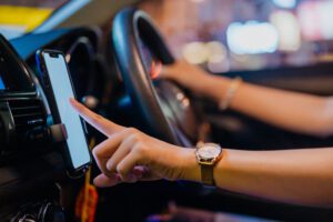 Women driver using smartphone whilst parked