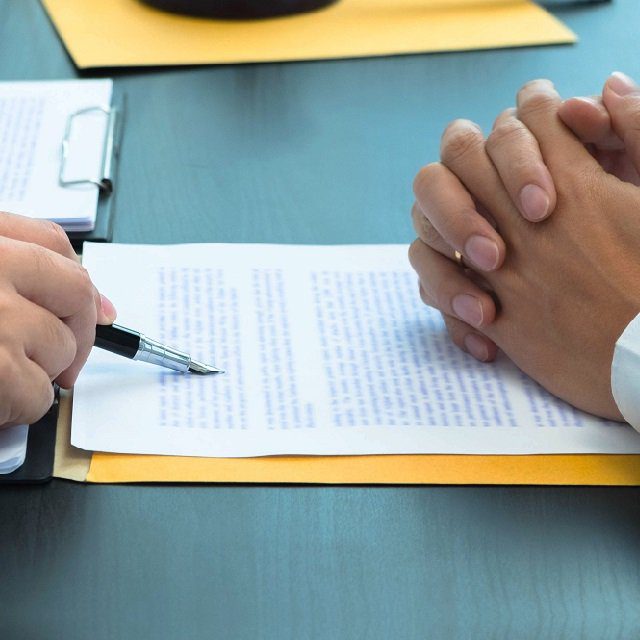 Document being reviewed by person with a pen