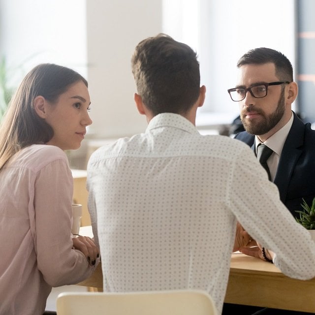 An insurance professional talks to clients. (Shutterstock, via DAMS)