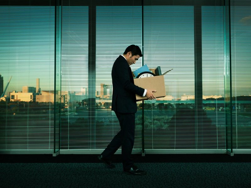 An office worker leaving his job with all his belongings in a box