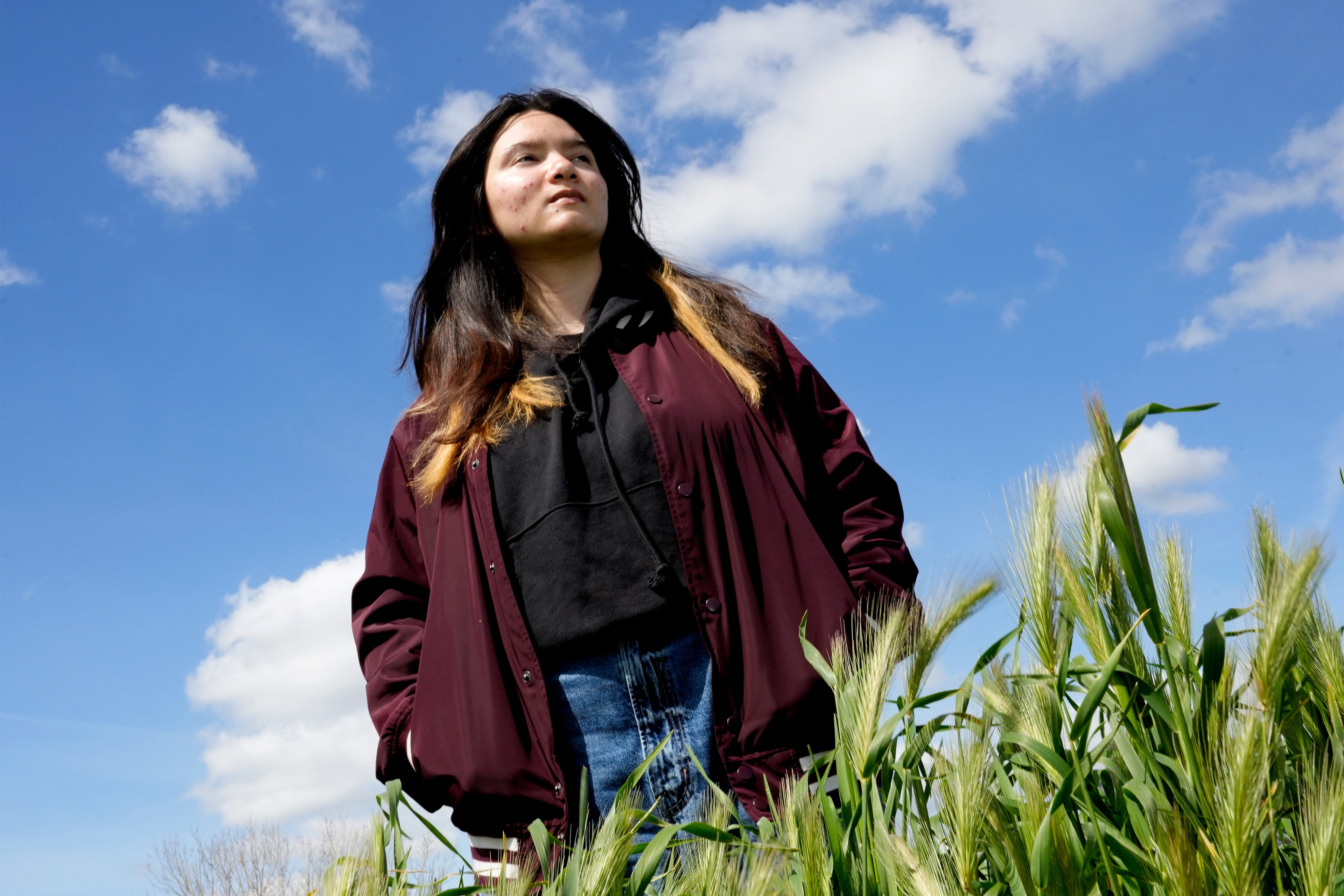 A photo of teenage girl posing for a portrait outside.