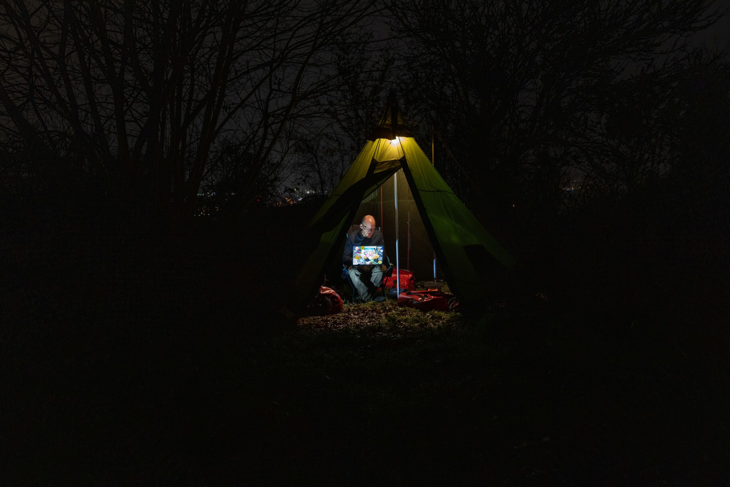 working on a laptop in a tent