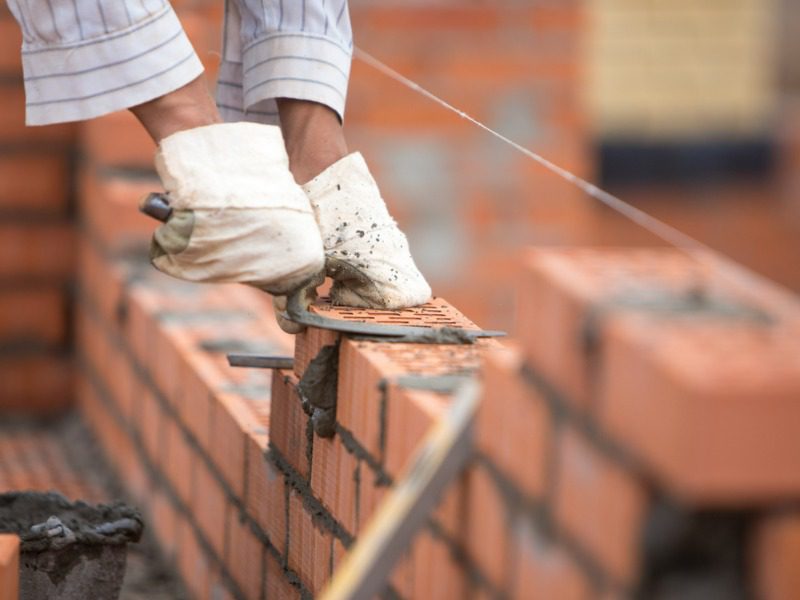 Laying a brick wall to represent building a business