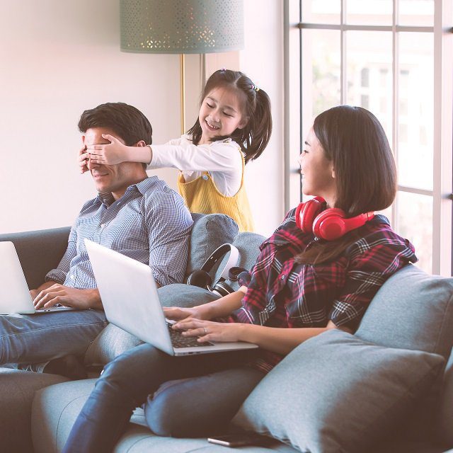 A mother, a father and a small child on a sofa.