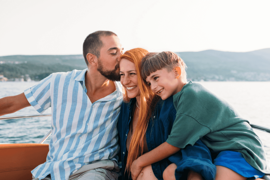 Man, woman and their little son spending day on sea in boat