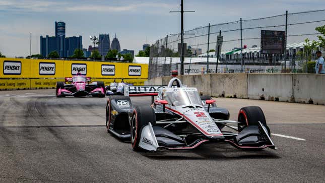 Josef Newgarden racing around the Belle Isle Circuit with the Renaissance Center in the background