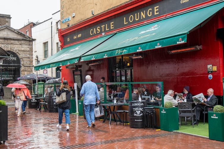 People walk past a pub in Ireland