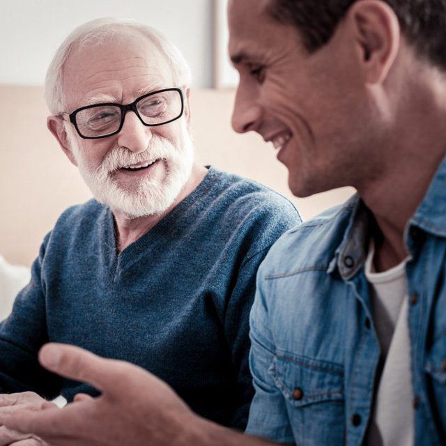 A younger man talking to an older man.