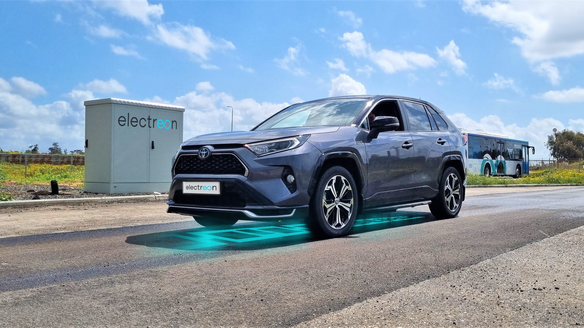 A blue Toyota RAV4 SUV parked on Electreon's test track, with blue skies in the background.