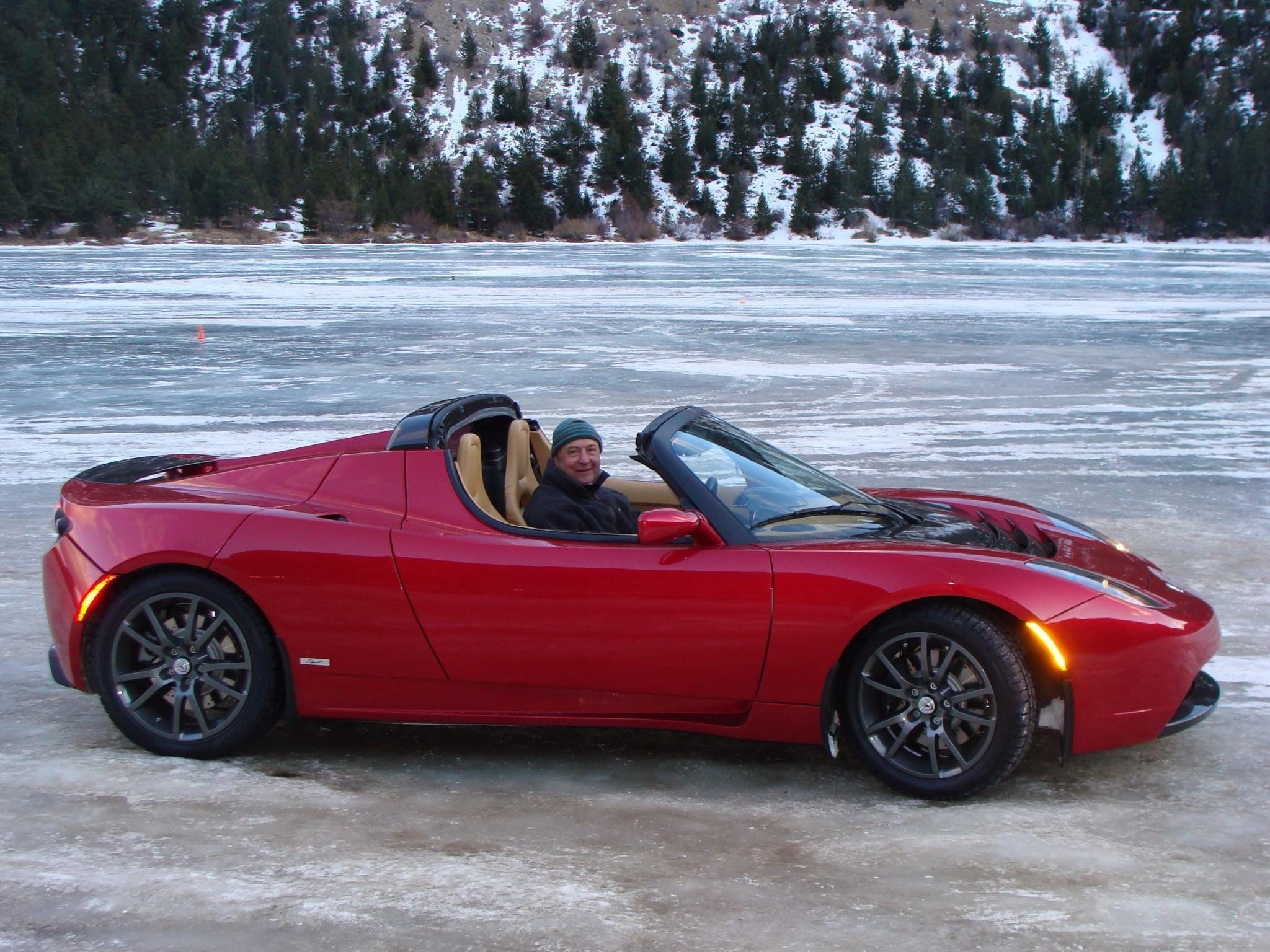 A man drives a red Tesla.