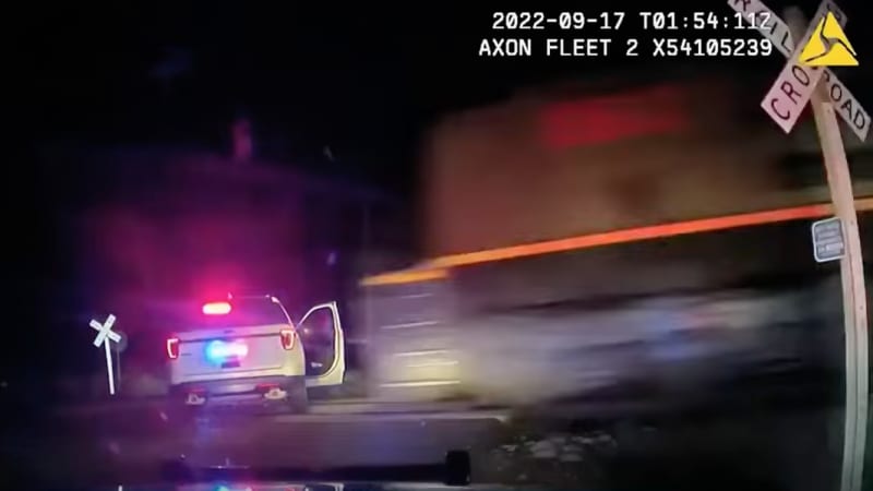 Officer who put woman in police car hit by train didn't know it was on the tracks, defense says