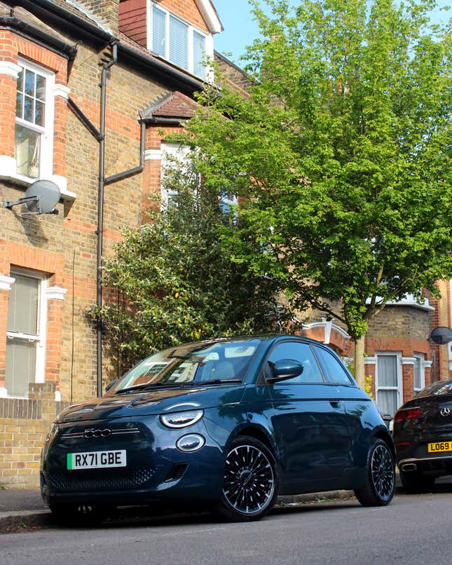 A photo of a Fiat 500 EV parked on a city street. 