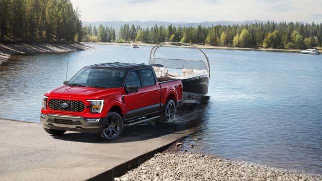 A photo of a red Ford F-150 pickup truck towing a boat. 