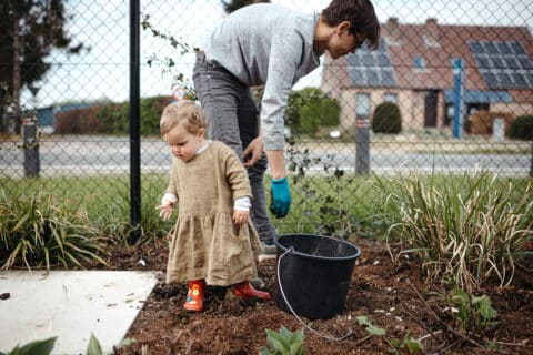 Dad weeding in the yard with the help of his daughter