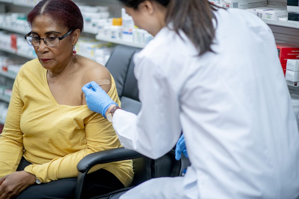 A woman is bandaged after having just received a vaccination in a pharmacy.