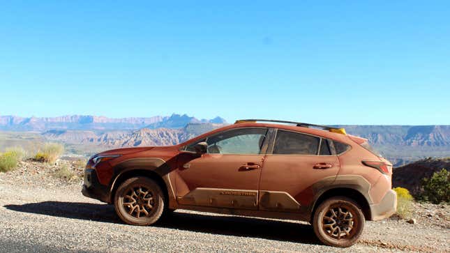 A side profile view of an orange Subaru Crosstrek. 