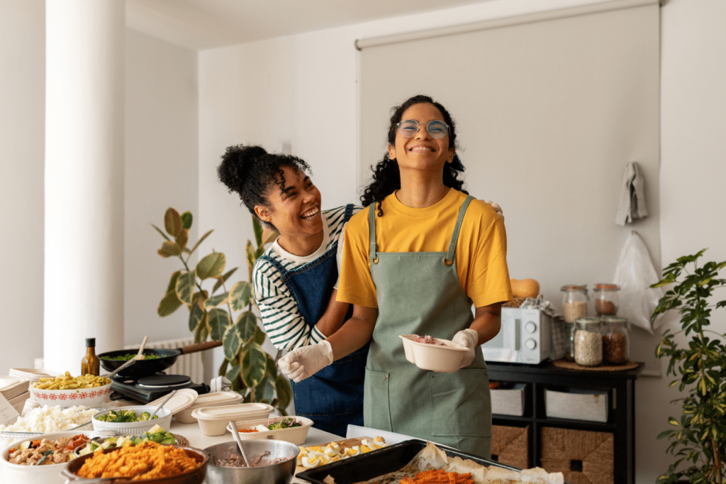 Female cooks having fun making different dishes prepared to serve at home