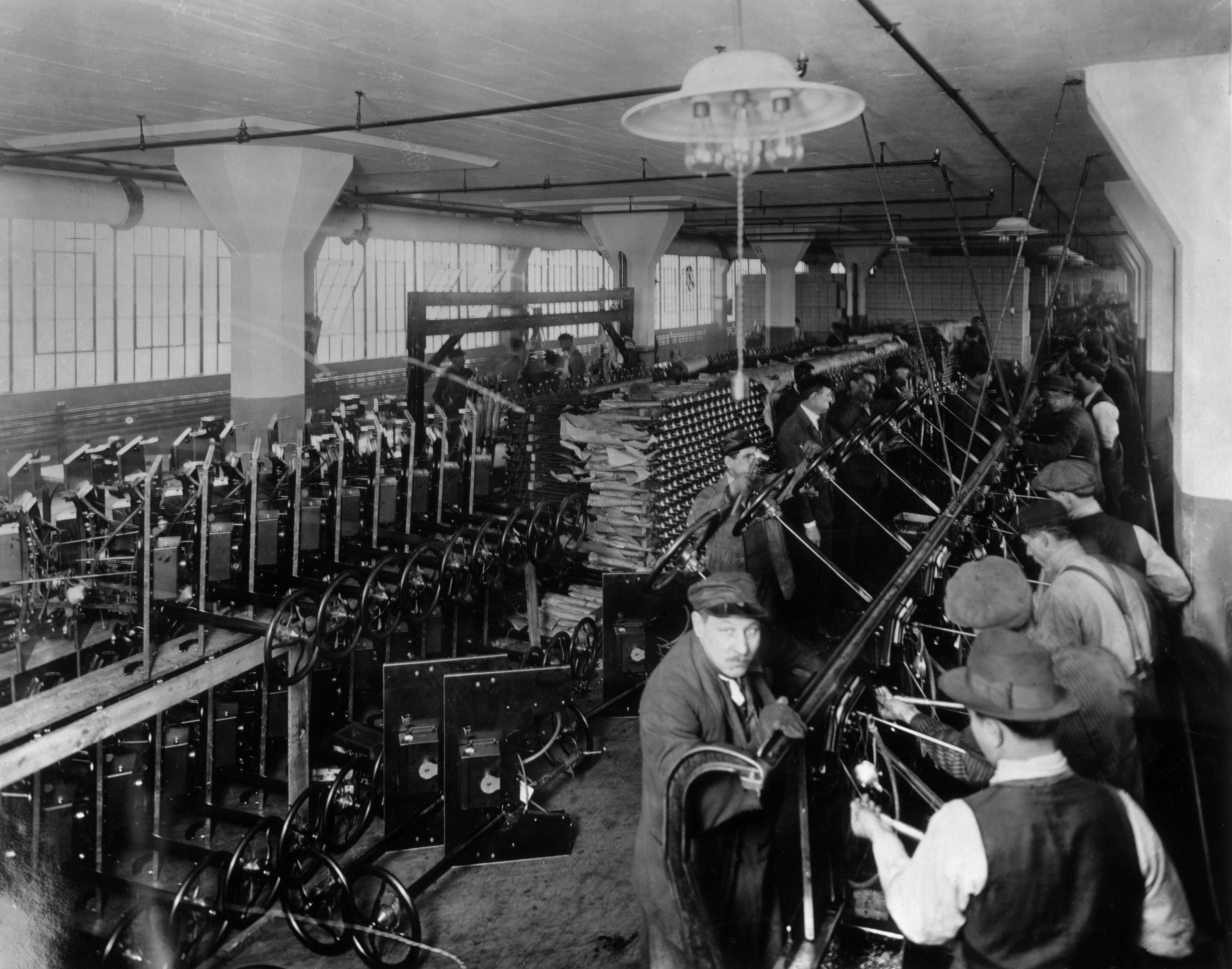 1913: Workers on an assembly line inside the Ford Motor Company factory at Highland Park, Michigan, constructing steering systems.